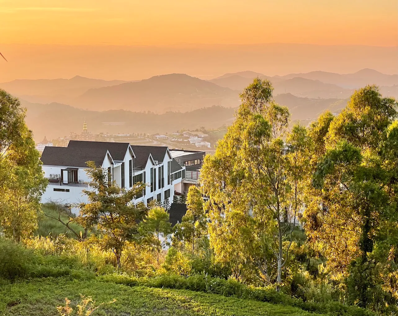 Golden-hour exterior view of MOYA Khaokho perched on a hillside overlooking the Khao Kho valley.